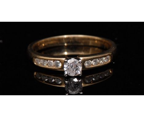A new diamond ring, central round brilliant cut solitaire diamond, raised above flanking shoulders each set with four smaller