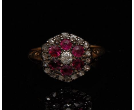 A Victorian old cut diamond and ruby flower head cluster ring, central diamond surrounded by a band of six ruby's and an oute