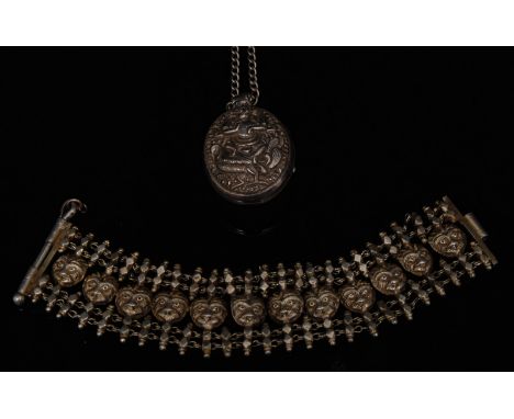 An Indian silver coloured locket pendant, oval cast two section locket, relief decorated with a deity and peacock to each sid