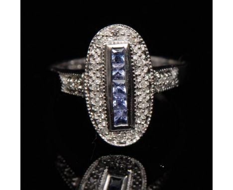 A new Art Deco style tanzanite and diamond ring, central row of five square cut tanzanite's, raised above a textured pave dia