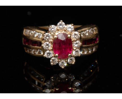 A ruby and diamond cluster ring, central red ruby, approx 0.80ct, surrounded by a band of twelve round brilliant cut diamonds