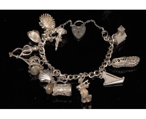 A silver charm bracelet, curb link bracelet suspending eleven charms including, Hedgehog, Chamber Stick, Harp, Stein,  Wateri