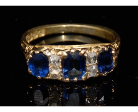 A sapphire and diamond seven stone ring, three graduated blue baguette cut sapphires, divided by pairs of old cut diamonds, 1