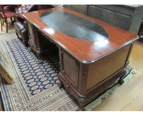 A CHIPPENDALE STYLE MAHOGANY PEDESTAL DESK with burr walnut panels and carved decoration on cabriole legs 170cm x 83cm