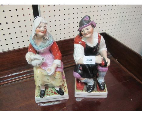 A PAIR OF LATE STAFFORDSHIRE FIGURES of a seated cobbler and his wife decorated in naturalistic colours 31cm high