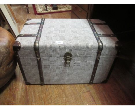 A SMALL UPHOLSTERED TRAVELLING TRUNK with strap hinges