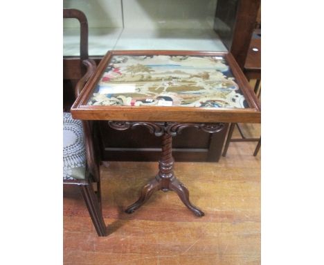 A VICTORIAN MAHOGANY OCCASIONAL TABLE the rectangular top with needlework panel above a carved apron on spiral twist support 