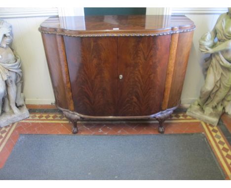 A FINE CHIPPENDALE MAHOGANY SIDE CABINET 19th Century the serpentine moulded top with gadrooned rim with panel doors on cabri