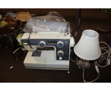 A NEW HOME SEWING MACHINE TOGETHER WITH A GLASS LAMP ETC.