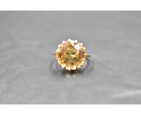 A citrine solitaire ring having a claw set basket mount on a yellow metal loop, no marks tests as 9ct gold, size O &amp; appr