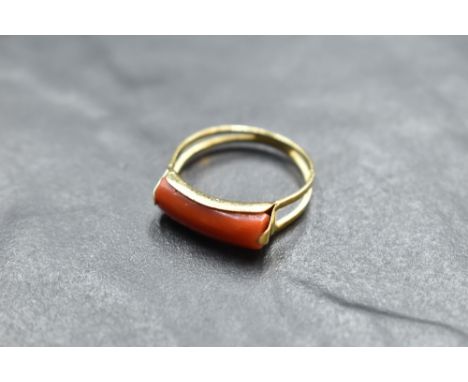 An Italian 750 grade yellow metal and coral ring, the shaped coral section between open the open and tapering double shank, f