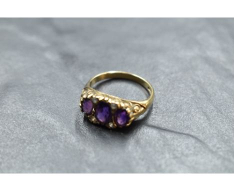 An amethyst trio ring having cubic zirconia spacers in a scrolled gallery mount and 9ct gold loop, size P &amp; approx 3.6g