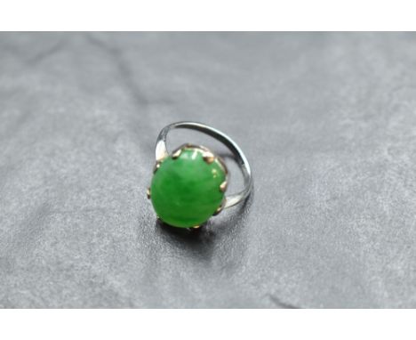 A jade style oval cabochon ring in a claw set mount on a white metal loop stamped 18ct, size L &amp; approx 3.7g