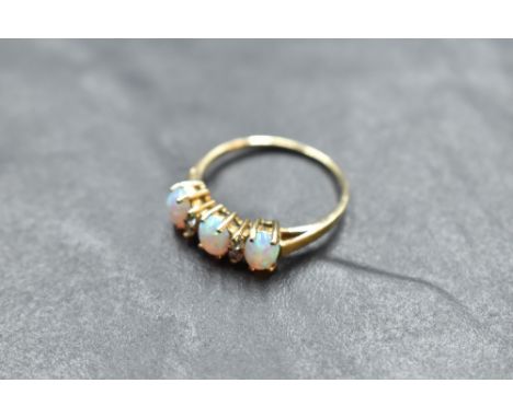 A 9ct gold opal and cubic zirconium ring, the oval opal cabochons interspersed by small brilliant-cut cubic zirconiums, marke