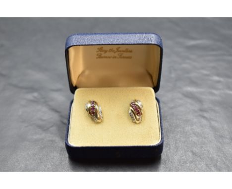 A pair of 9ct gold stud earrings having ruby and diamond chip decoration to moulded panels, approx 3.2g