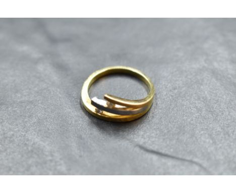 A two tone 750 grade white and yellow metal diamond set ring, the yellow metal band issuing a white and yellow metal branches