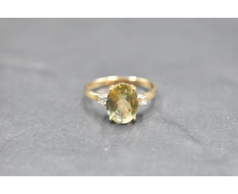 An oval yellow sapphire ring flanked by two small diamonds on a 9ct gold loop, size O &amp; approx 2.5g