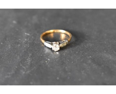 A diamond solitaire ring approx 0.25ct in a raised claw set mount having diamond chip set shoulders on a yellow metal loop st