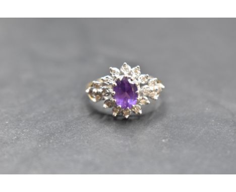 An amethyst and diamond open cluster ring with diamond set shoulders, all in illusionary mounts, on a 14ct gold loop, size Q 