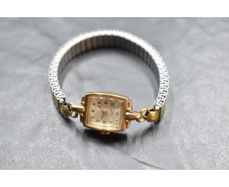 A lady's vintage 9ct gold wrist watch by Rotary having Arabic numeral dial to rectangular face in plain gold case on a gold p