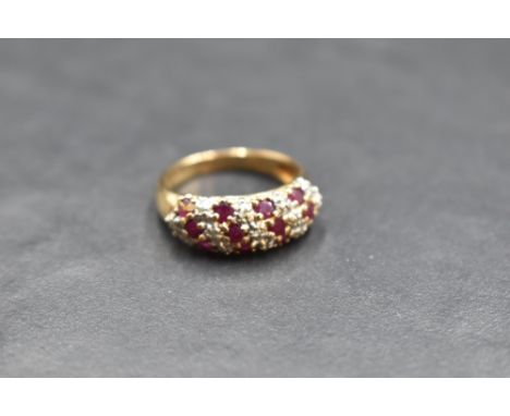 A ruby and diamond chip triple row band ring having moulded shoulders to a 9ct gold loop, size O &amp; approx 4g