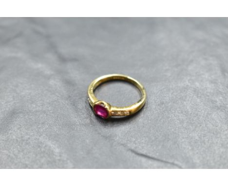 A ruby and diamond ring having a central oval ruby having diamond set shoulders on an 18ct gold loop, size N &amp; approx 3.4