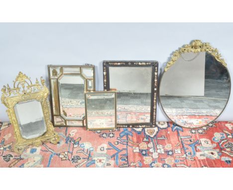 A collection of five mirrors, one with a wooden frame with mother of pearl inlay, a gilt metal example stand example, of vary