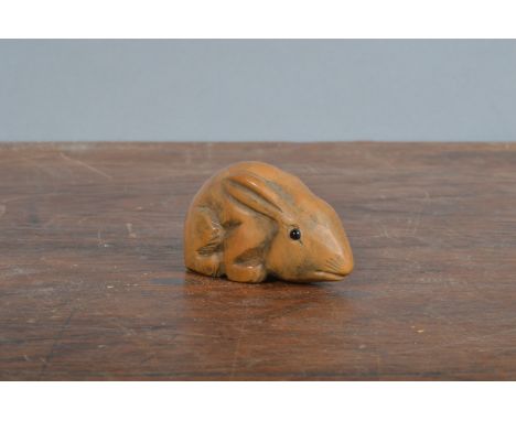 A late Meji period hand-carved Japanese netsuke,&nbsp; of hardwood depicting a hare, glass eyes. 4.5 cm long. (1)