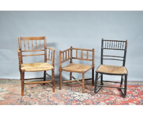 Three 19th century and later rush seated chairs, comprising an armchair, a bobbin corner chair, and an ebonised rocking chair