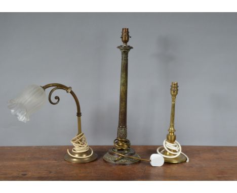 A cast metal Regency style table lamp,  with fluted Corinthian column, 53 cm tall, together with two brass table lamps, one w