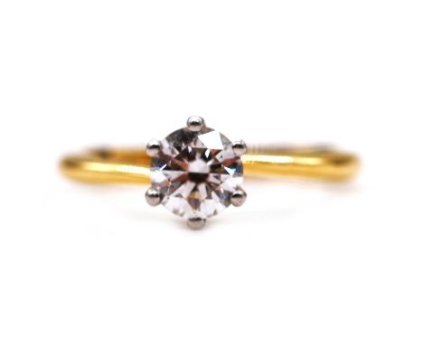 A diamond solitaire ring, the brilliant cut stone claw set in an 18 carat yellow and white gold mount ring size P, the diamon