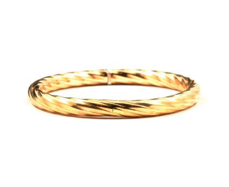 A modern 9 carat yellow gold half hinged bangle, 6mm wide hollow twisted design, integral sliding fastener, internal dimensio