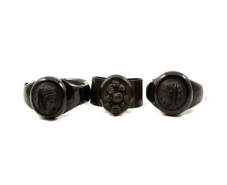 A vulcanite bangle and two mixed material jet style expanding bracelets, a vulcanite bangle, 43x35mm oval carved floral panel