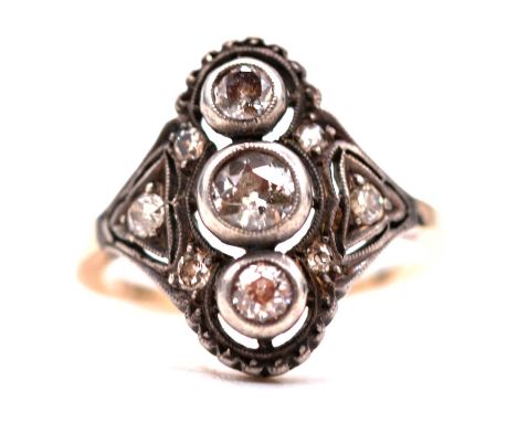 A diamond three stone ring in the Art Deco style, the three old cut diamonds individually collet set vertically with three fu