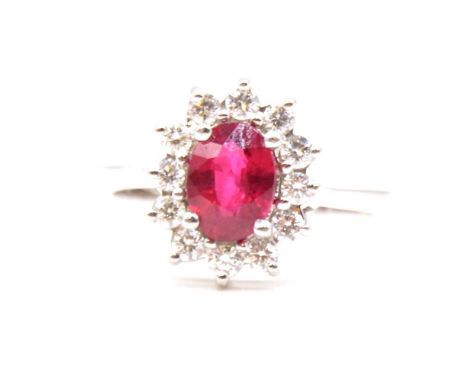 A ruby and diamond cluster ring, the oval mixed cut ruby, 7.5x5.5mm, claw set and surrounded by twelve brilliant cut diamonds