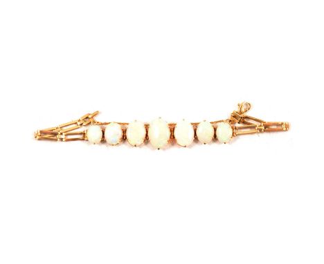 An opal bracelet, seven oval cabochon cut opals individually claw set in yellow metal mounts with a length of two bar gate li