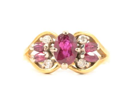 A ruby and diamond cluster ring, an oval mixed cut ruby claw set with a pair of smaller marquise cut rubies and two brilliant
