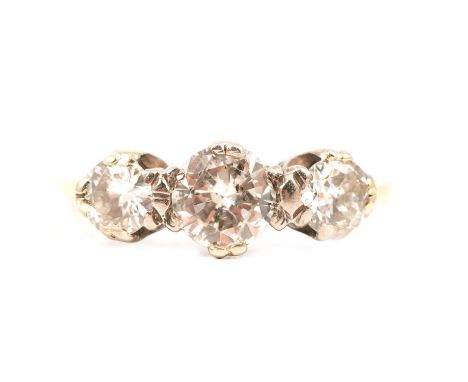A diamond three stone ring, the brilliant cut stones claw set in a yellow and white metal traditional three stone mount ring 