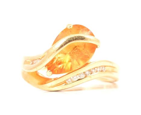 A citrine and diamond crossover ring, the mixed pear cut citrine, 12x8mm, claw set with seven brilliant cut diamonds to one c