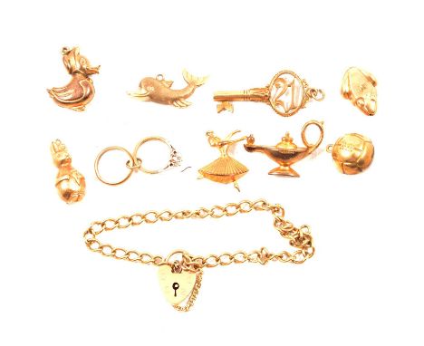 A 9 carat yellow gold hollow curb link bracelet and nine charms, a 9 carat yellow gold hollow curb link bracelet, padlock fas