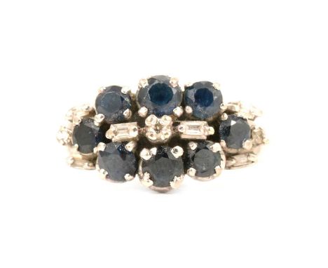 A sapphire and diamond cluster ring, the eight brilliant cut sapphires with two baguette cut and one brilliant cut diamond to