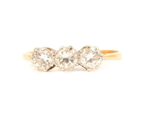 A diamond three stone ring, the brilliant cut stones claw set in a yellow and white metal traditional three stone mount ring 
