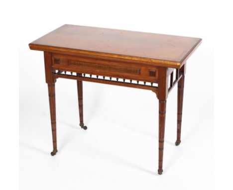 A Victorian Aesthetic style mahogany and walnut card table, the fold out rectangular top above a frieze and gallery, on taper