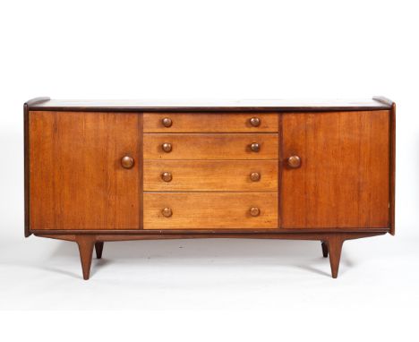 A mid century teak sideboard, with four central graduated short drawers, flanked by two single cupboards doors, enclosing a s