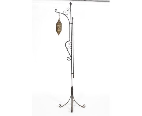 A Middle Eastern brass pierced lantern with pierced floral decoration, and wrought iron stand, 191 cm high 