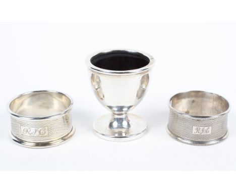 A silver christening set, comprising: an egg-cup and two engine turned napkin rings engraved RJC, Birmingham, 1956 to the egg