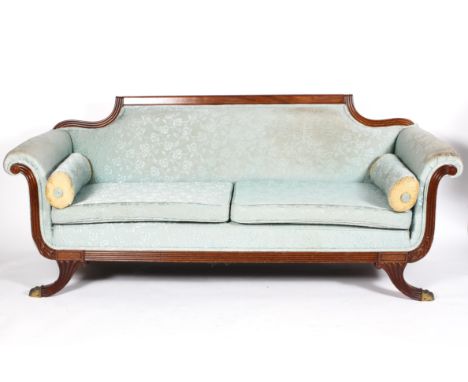 A Regency style mahogany sofa, the padded back above scrolled arms, cushion seat and splayed legs, 84cm high x 202cm wide x 8