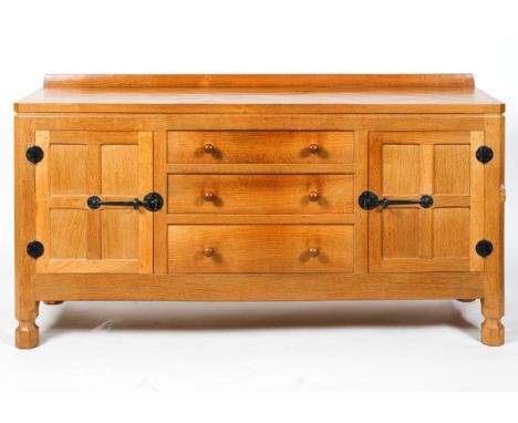 Robert Mouseman Thompson workshop, an oak sideboard, the raised back above three drawers flanked by a pair of doors, on octag
