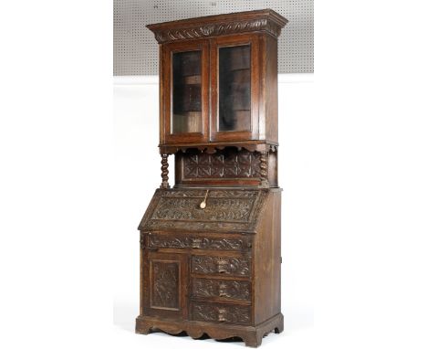 A Victorian carved oak bureau bookcase, carved with flower heads in lozenges, with barley twist supports,with two glazed door