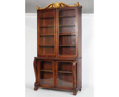 A Regency inlaid brass and parcel-gilt bookcase, the gilt scroll palmette  pediment above two glazed doors enclosing four adj